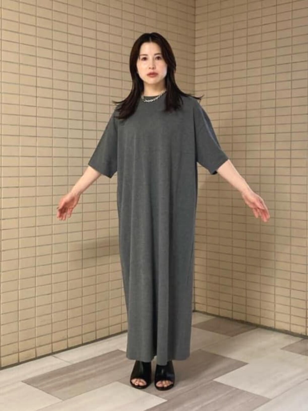 ブラック系のサンダル、グレー系のワンピース、ブルー系のブルゾンを着用したレディースの夏コーディネートの4枚目の写真