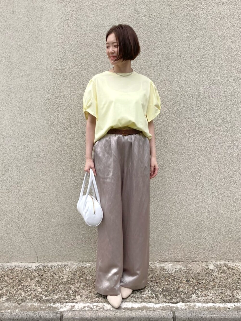 イエロー系のTシャツ/カットソー、ベージュ系のその他パンツ、ホワイト系のバッグを着用したレディースの夏コーディネートの5枚目の写真