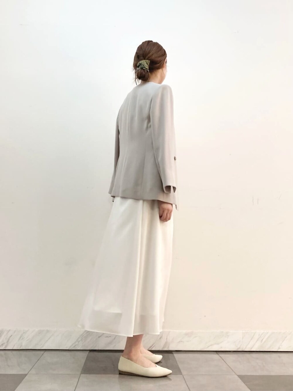 ホワイト系のスカート、グレー系のスーツジャケットを着用したレディースの春コーディネートの5枚目の写真