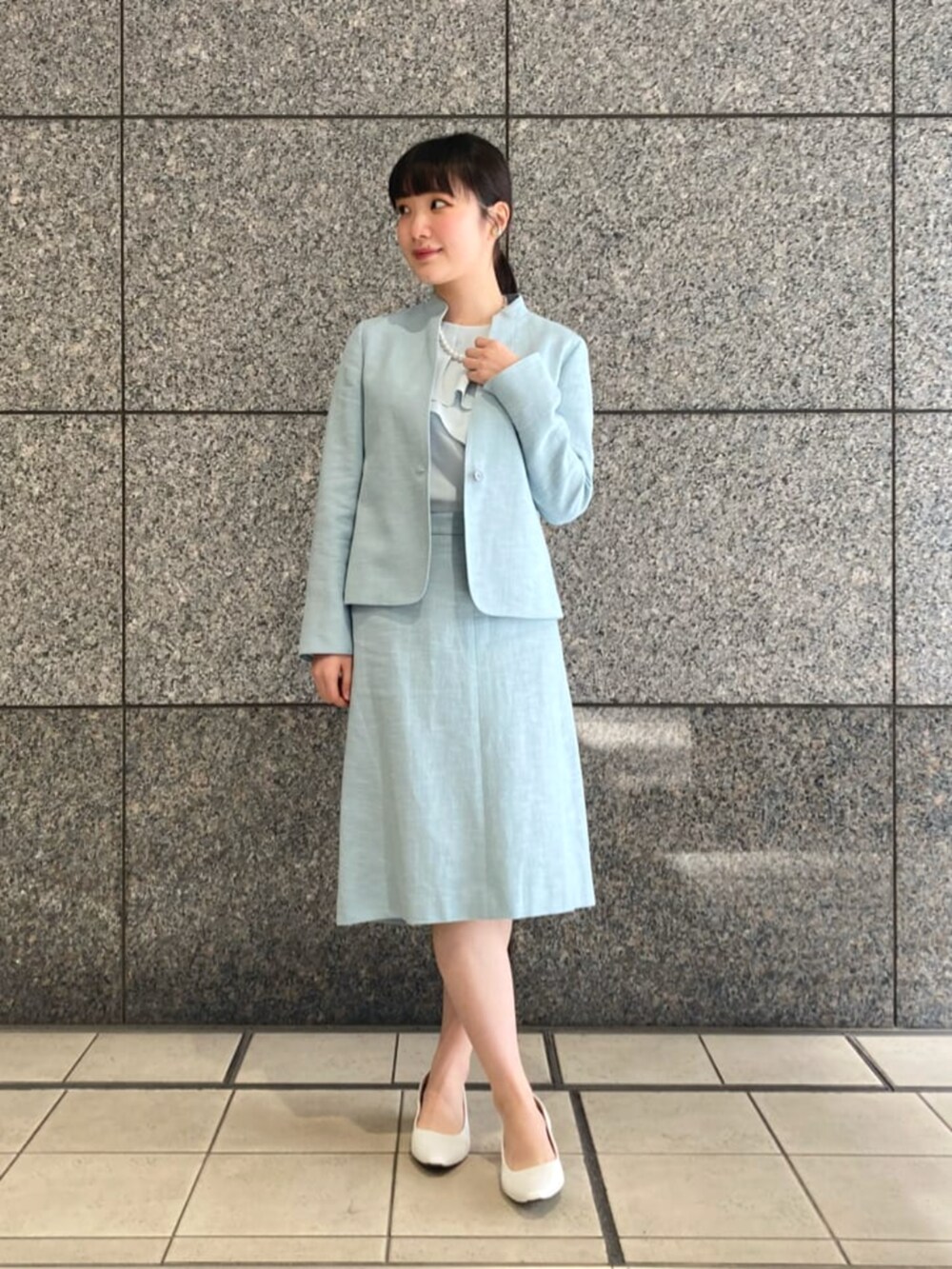 ブルー系のノーカラージャケット、ブルー系のスカートを着用したレディースの春コーディネートの2枚目の写真