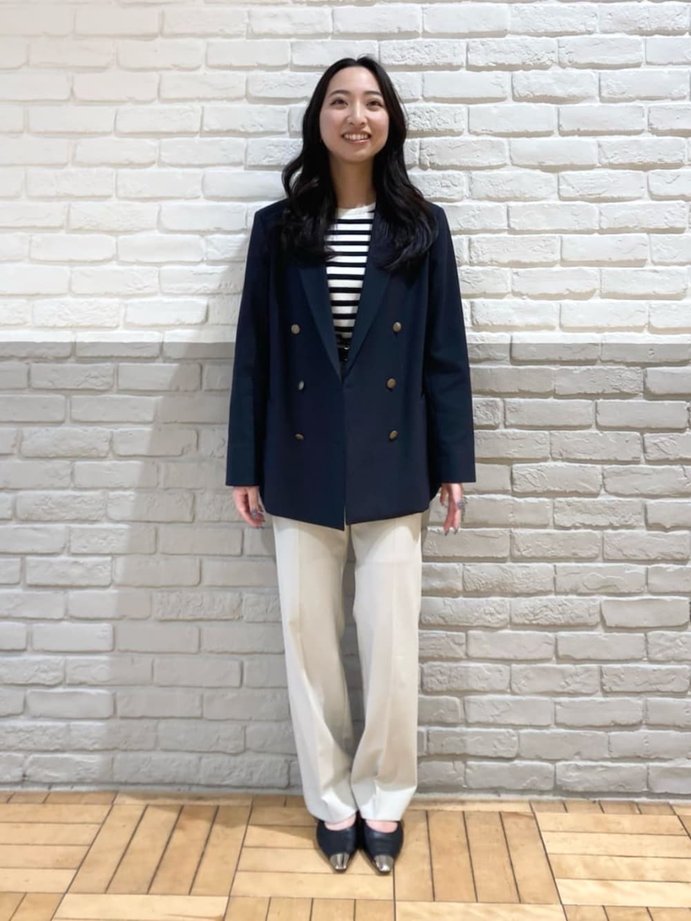 ブルー系のセットアップ、ホワイト系のニット/セーター、ベージュ系のその他パンツを着用したレディースの春コーディネートの4枚目の写真