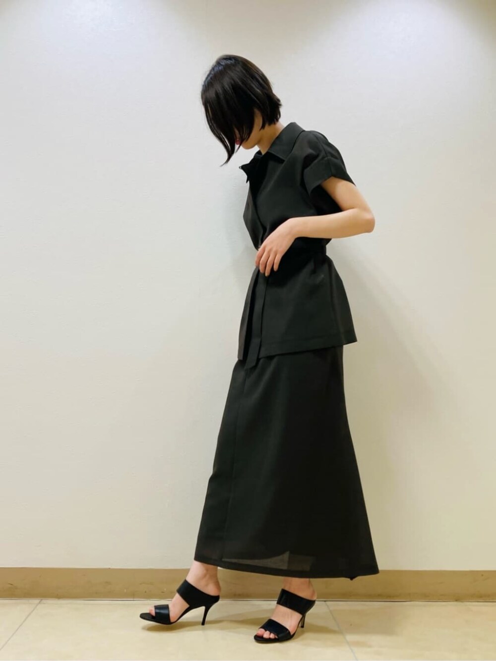 ブラウン系のベスト、ブラウン系のスカート、ゴールド系のネックレスを着用したレディースの夏コーディネートの3枚目の写真