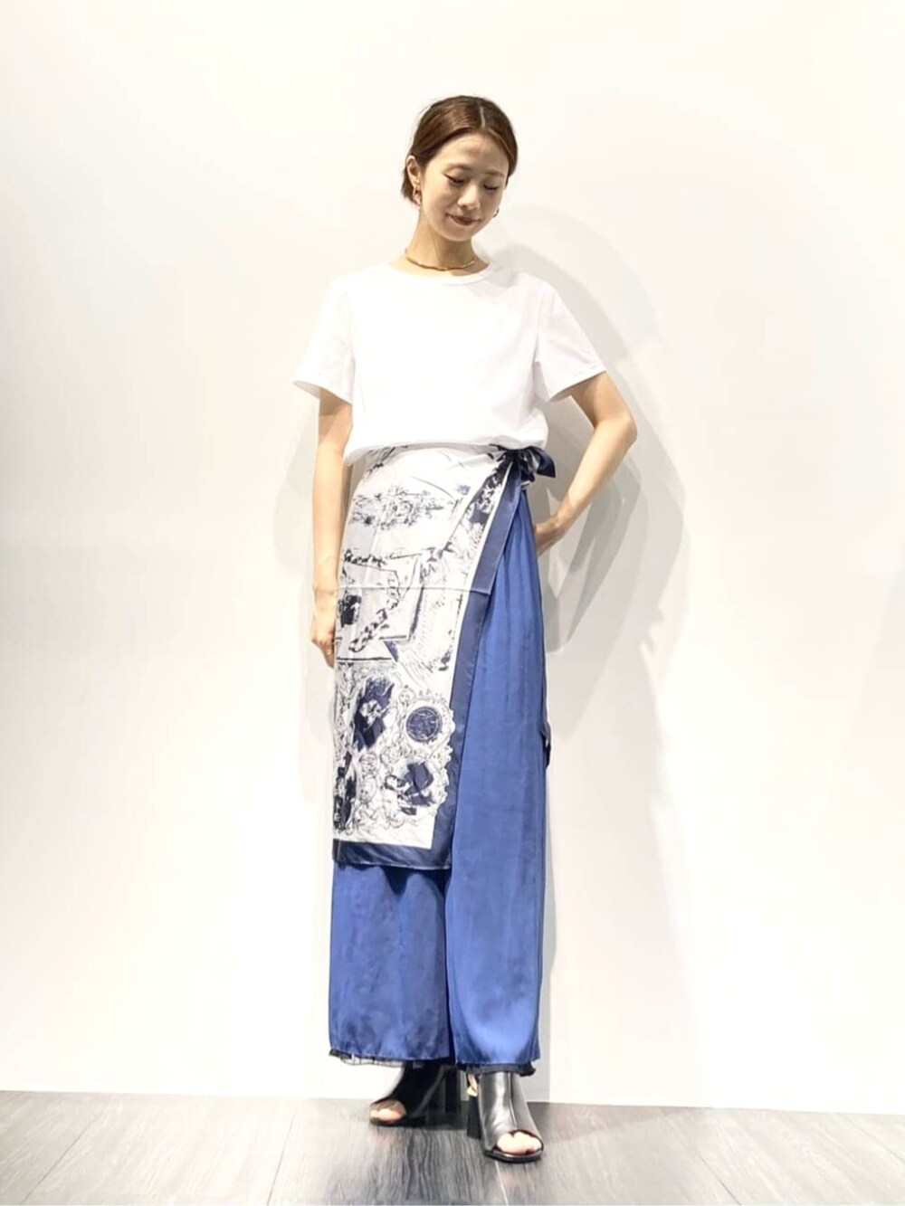 ブラック系のサンダル、ホワイト系のTシャツ/カットソー、ブルー系のその他パンツを着用したレディースの夏コーディネートの2枚目の写真