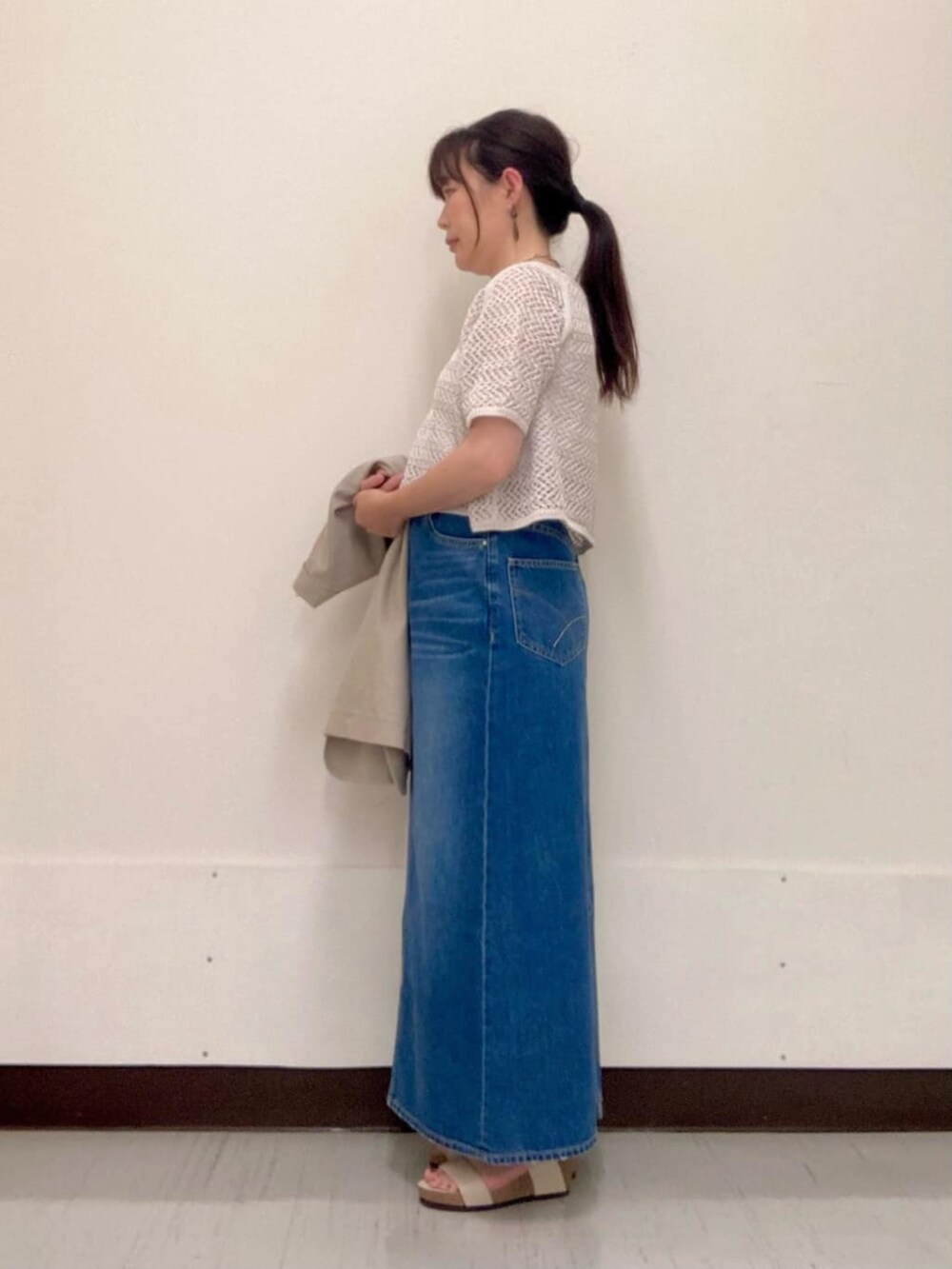 グレー系のスカート、ベージュ系のテーラードジャケット、グレー系のアンサンブルを着用したレディースの夏コーディネートの3枚目の写真