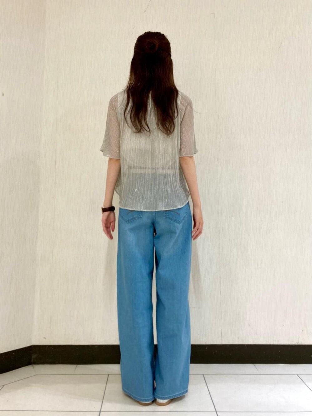 シルバー系のTシャツ/カットソー、ブルー系のデニムパンツを着用したレディースの夏コーディネートの4枚目の写真