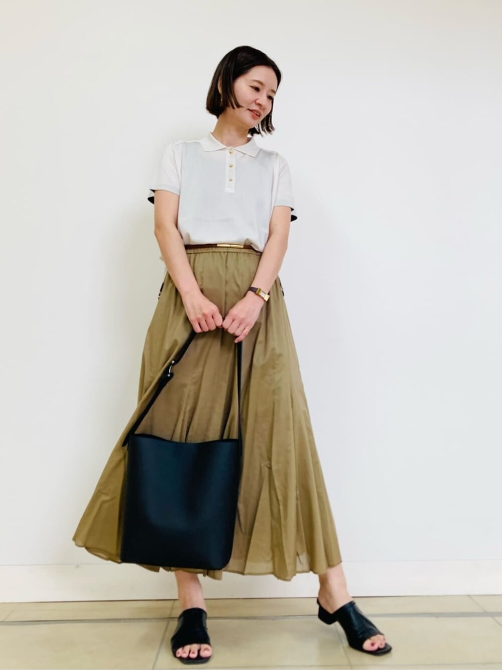 ホワイト系のニット/セーター、イエロー系のスカートを着用したレディースの夏コーディネートの2枚目の写真
