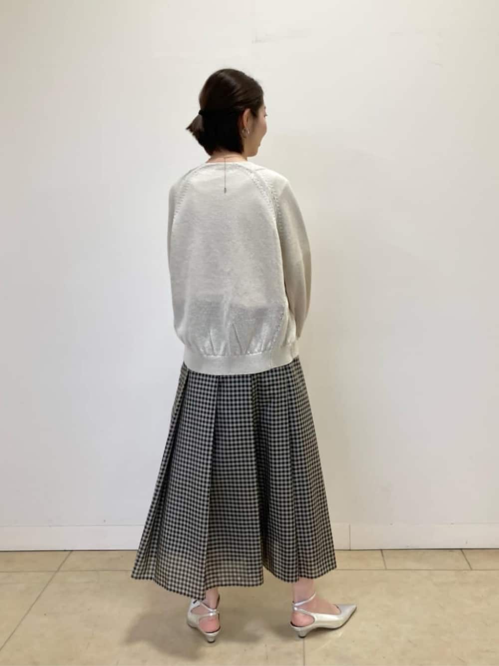 ベージュ系のカーディガン/ボレロ、ホワイト系のTシャツ/カットソー、ブラック系のスカートを着用したレディースの春コーディネートの5枚目の写真