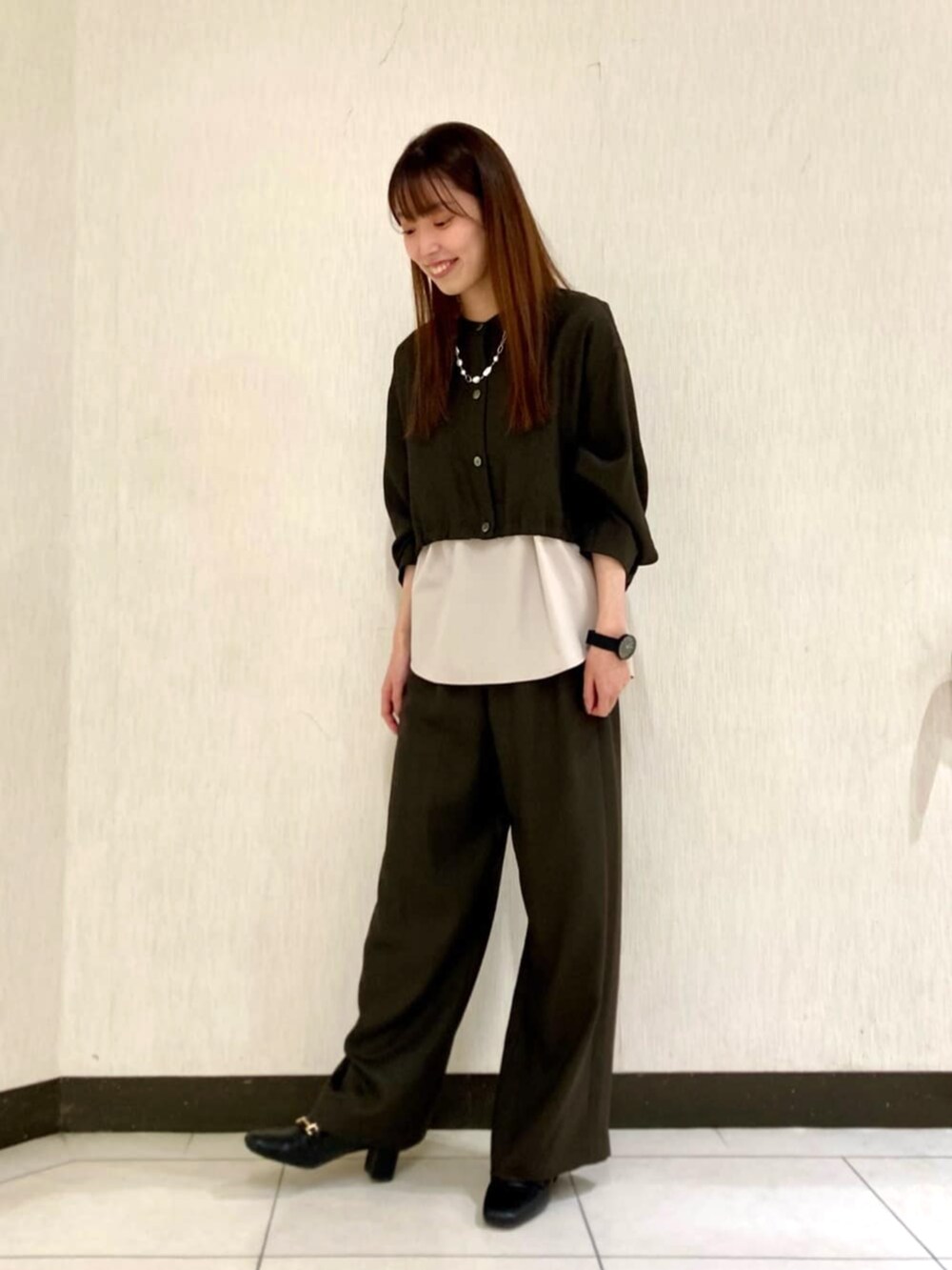 ブラウン系のその他パンツ、ホワイト系のネックレスを着用したレディースの春コーディネートの2枚目の写真