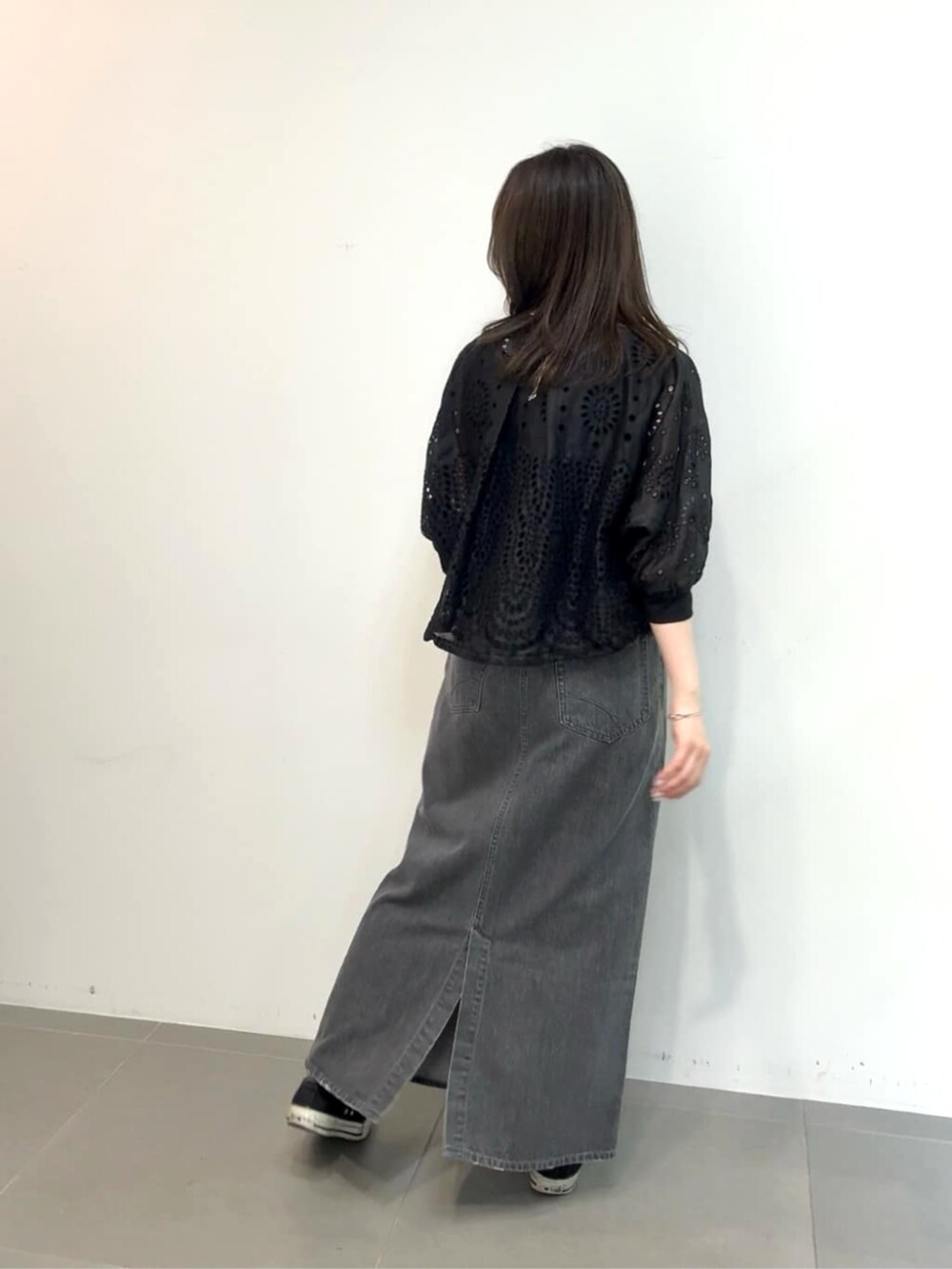 グレー系のスカート、ブラック系のタンクトップ、ブラック系のブルゾンを着用したレディースの夏コーディネートの4枚目の写真