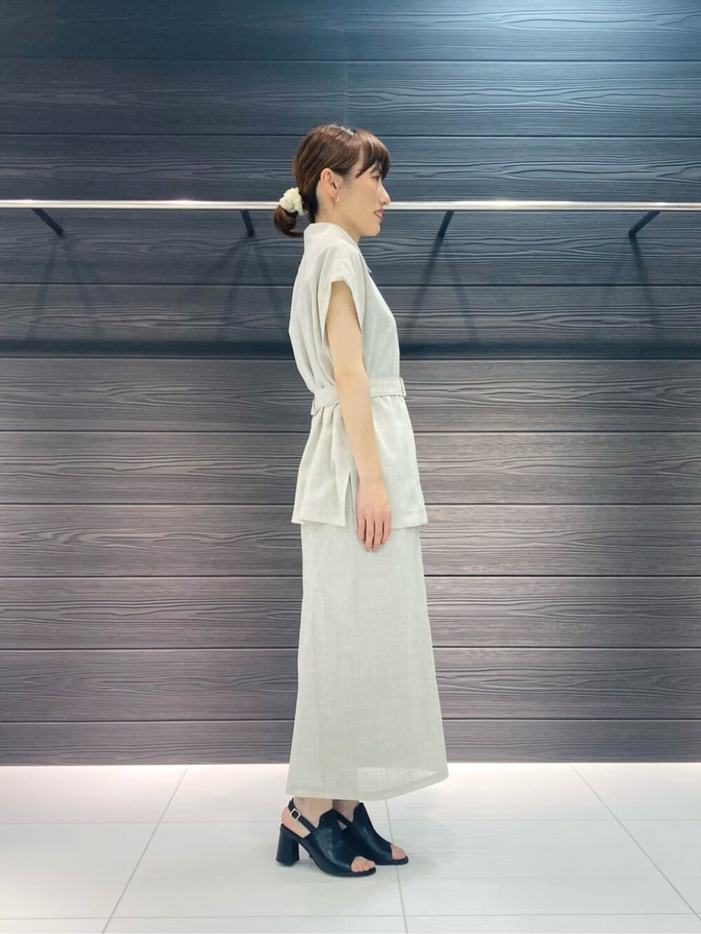 ブラック系のサンダル、ホワイト系のスカート、ホワイト系のベストを着用したレディースの夏コーディネートの2枚目の写真