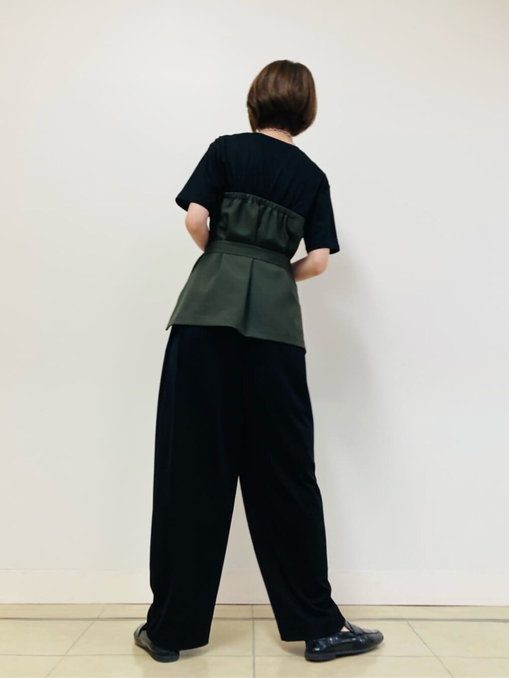 グリーン系のTシャツ/カットソー、ブラック系のパンツを着用したレディースの夏コーディネートの4枚目の写真