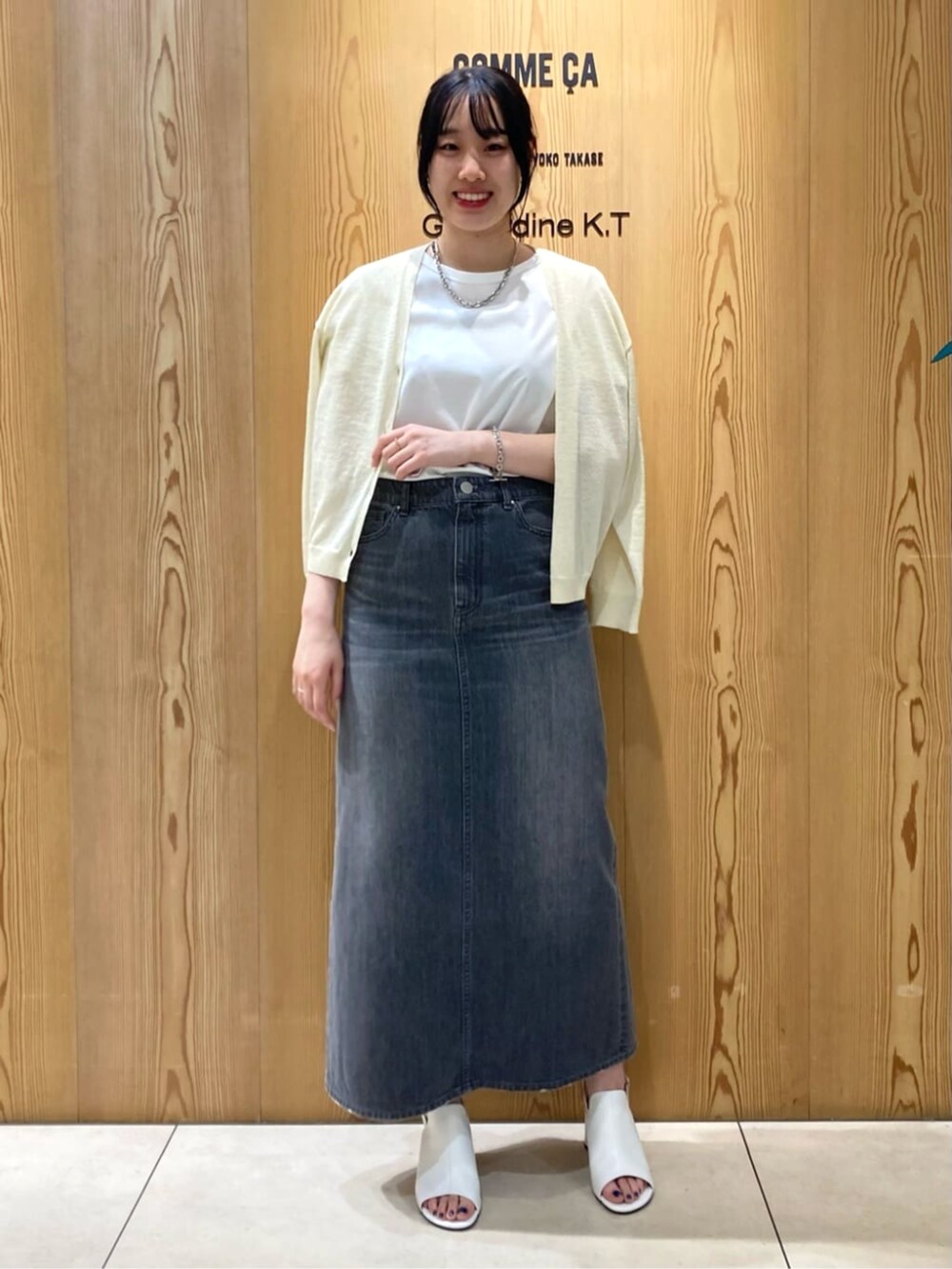 イエロー系のカーディガン/ボレロ、ホワイト系のサンダル、グレー系のスカートを着用したレディースの夏コーディネートの2枚目の写真