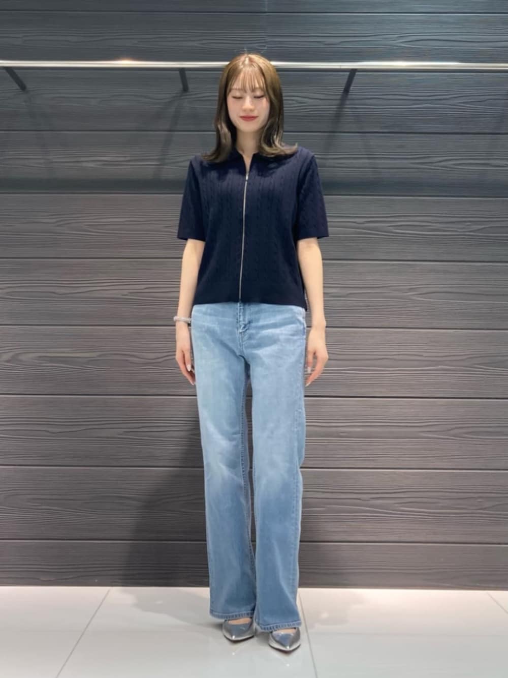 ブルー系のデニムパンツ、ブルー系のカーディガン/ボレロ、ブラウン系のボストンバッグを着用したレディースの春コーディネートの4枚目の写真