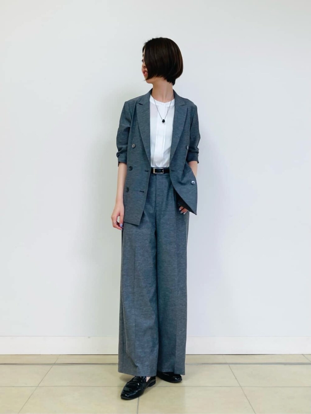 グレー系のテーラードジャケット、グレー系のその他パンツ、ホワイト系のシャツ/ブラウスを着用したレディースの秋コーディネートの2枚目の写真