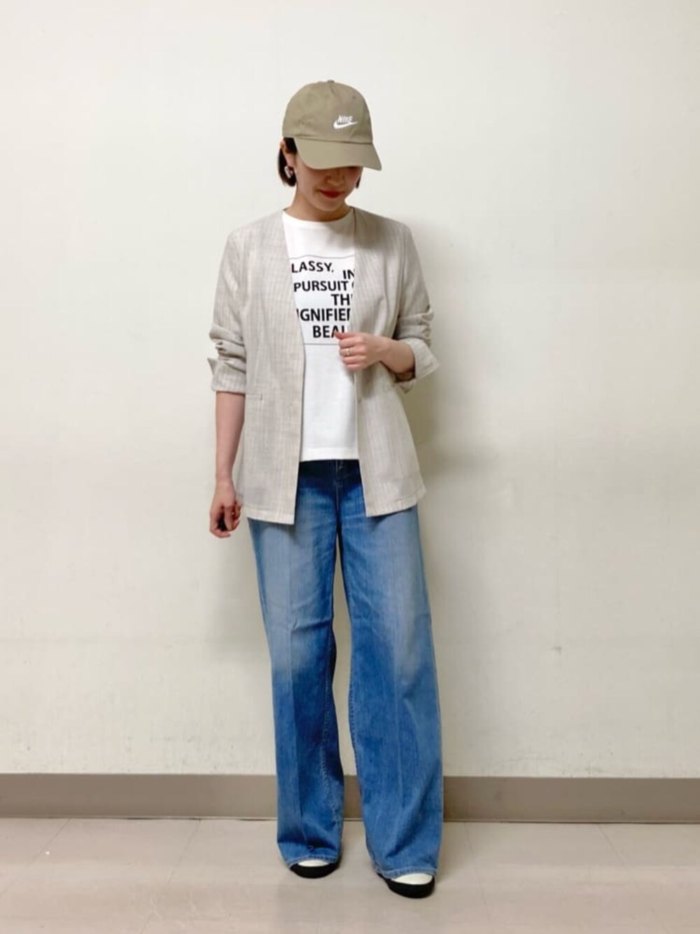 ブルー系のデニムパンツ、ホワイト系のTシャツ/カットソー、ホワイト系のノーカラージャケットを着用したレディースの夏コーディネートの2枚目の写真