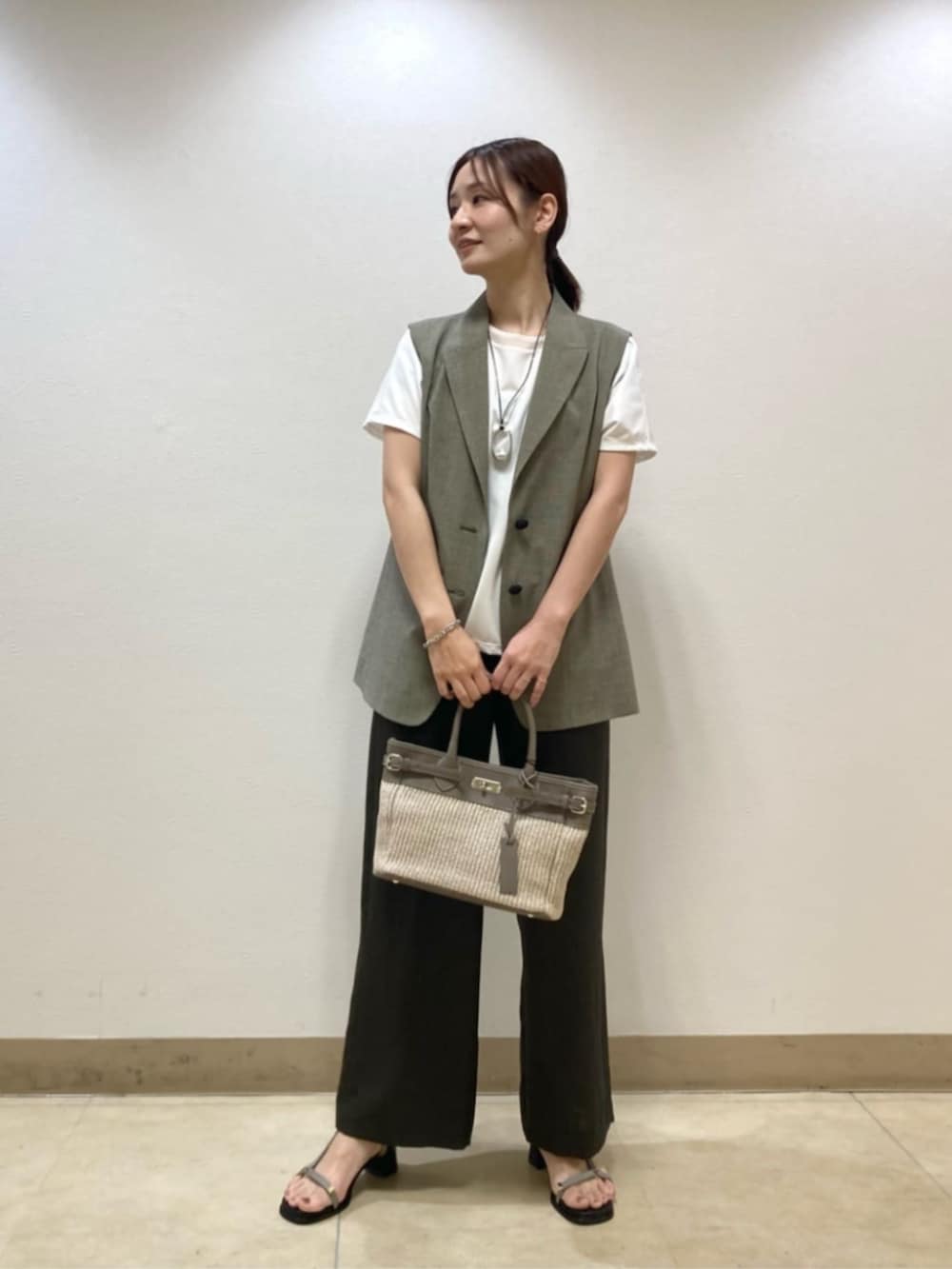 ベージュ系のベスト、ブラウン系のその他パンツ、ホワイト系のTシャツ/カットソーを着用したレディースの春コーディネートの2枚目の写真