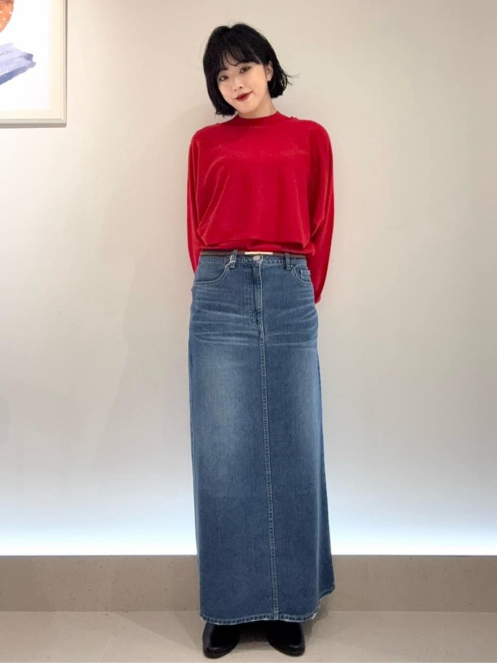 ブルー系のスカート、レッド系のアンサンブルを着用したレディースの秋コーディネートの3枚目の写真