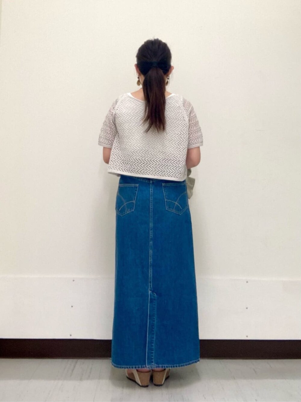 グレー系のスカート、ベージュ系のテーラードジャケット、グレー系のアンサンブルを着用したレディースの夏コーディネートの4枚目の写真