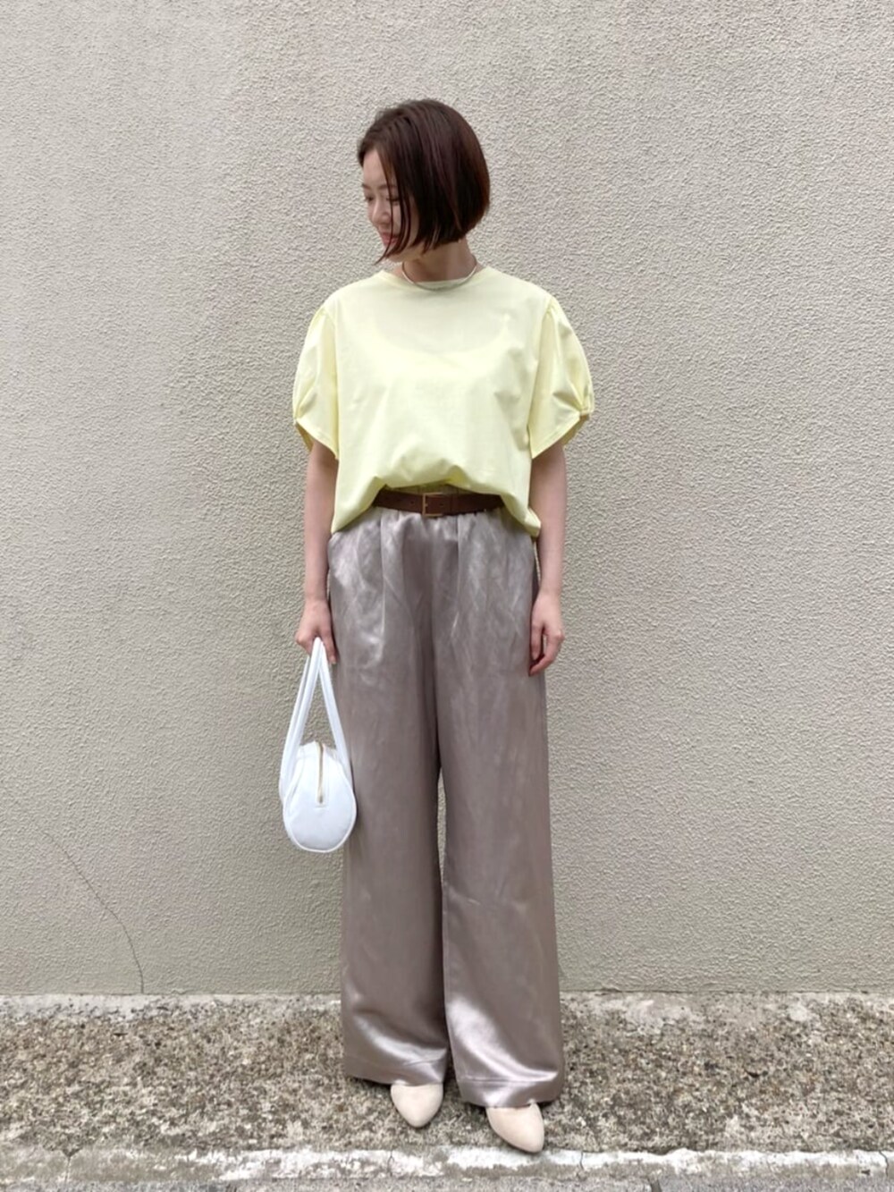 イエロー系のTシャツ/カットソー、ベージュ系のその他パンツ、ホワイト系のバッグを着用したレディースの夏コーディネートの3枚目の写真