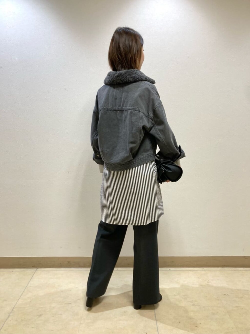 グレー系のその他パンツ、グレー系のデニムジャケット、ブラック系のブーツを着用したレディースの冬コーディネートの5枚目の写真