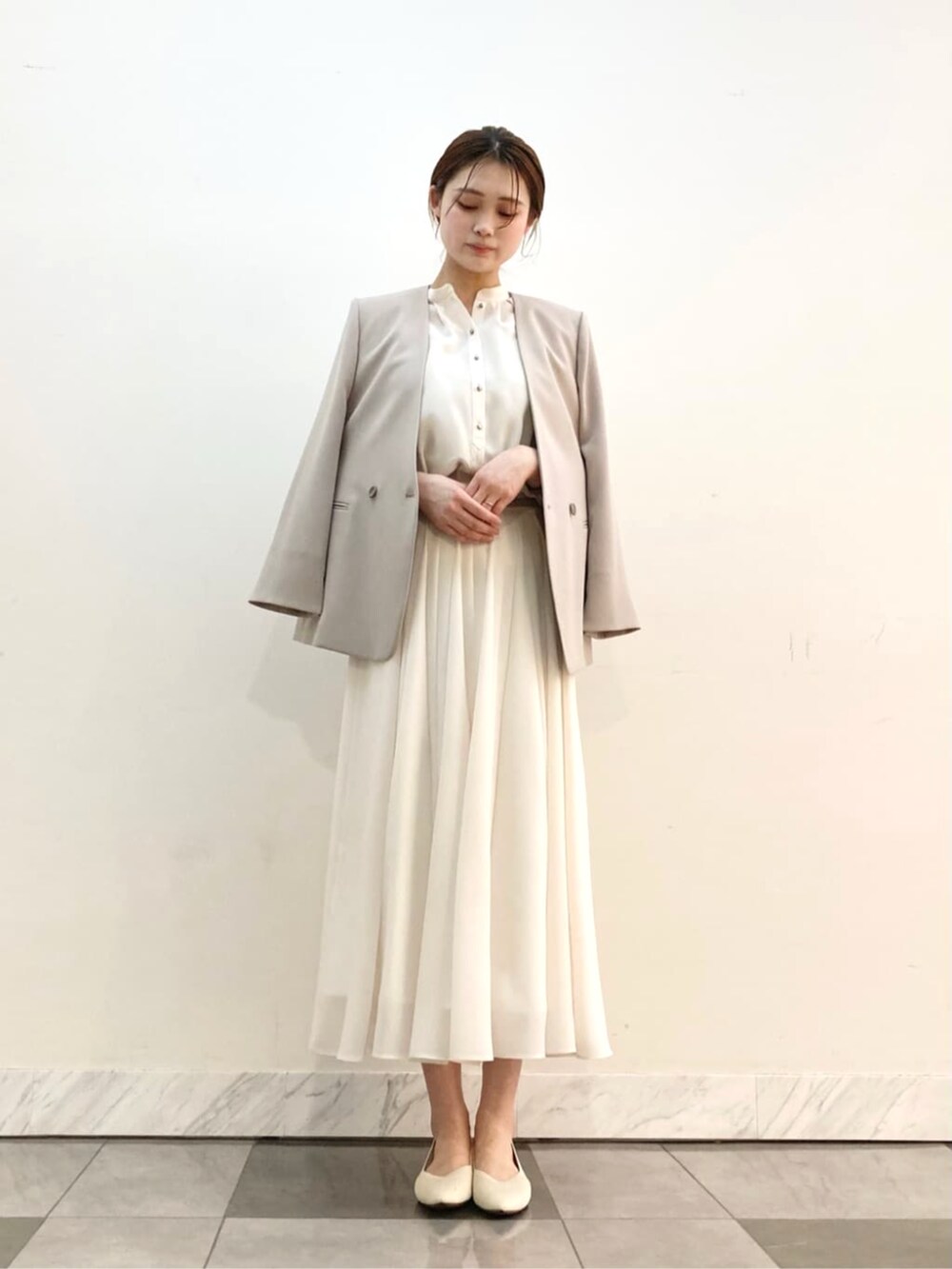 ホワイト系のスカート、グレー系のスーツジャケットを着用したレディースの春コーディネートの4枚目の写真