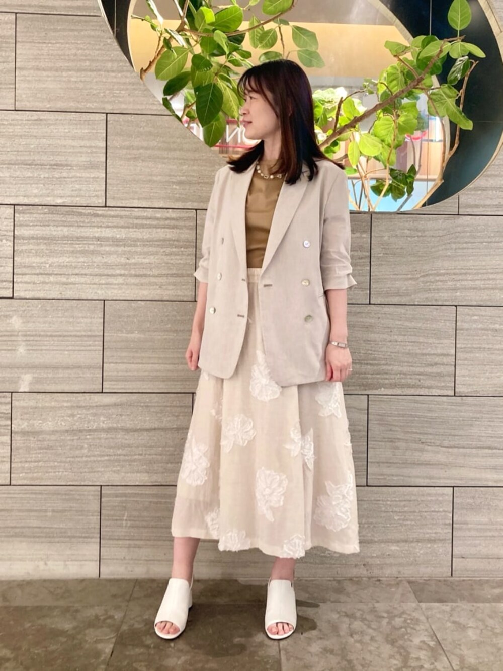 イエロー系のTシャツ/カットソー、ホワイト系のサンダル、ベージュ系のテーラードジャケットを着用したレディースの春コーディネートの2枚目の写真