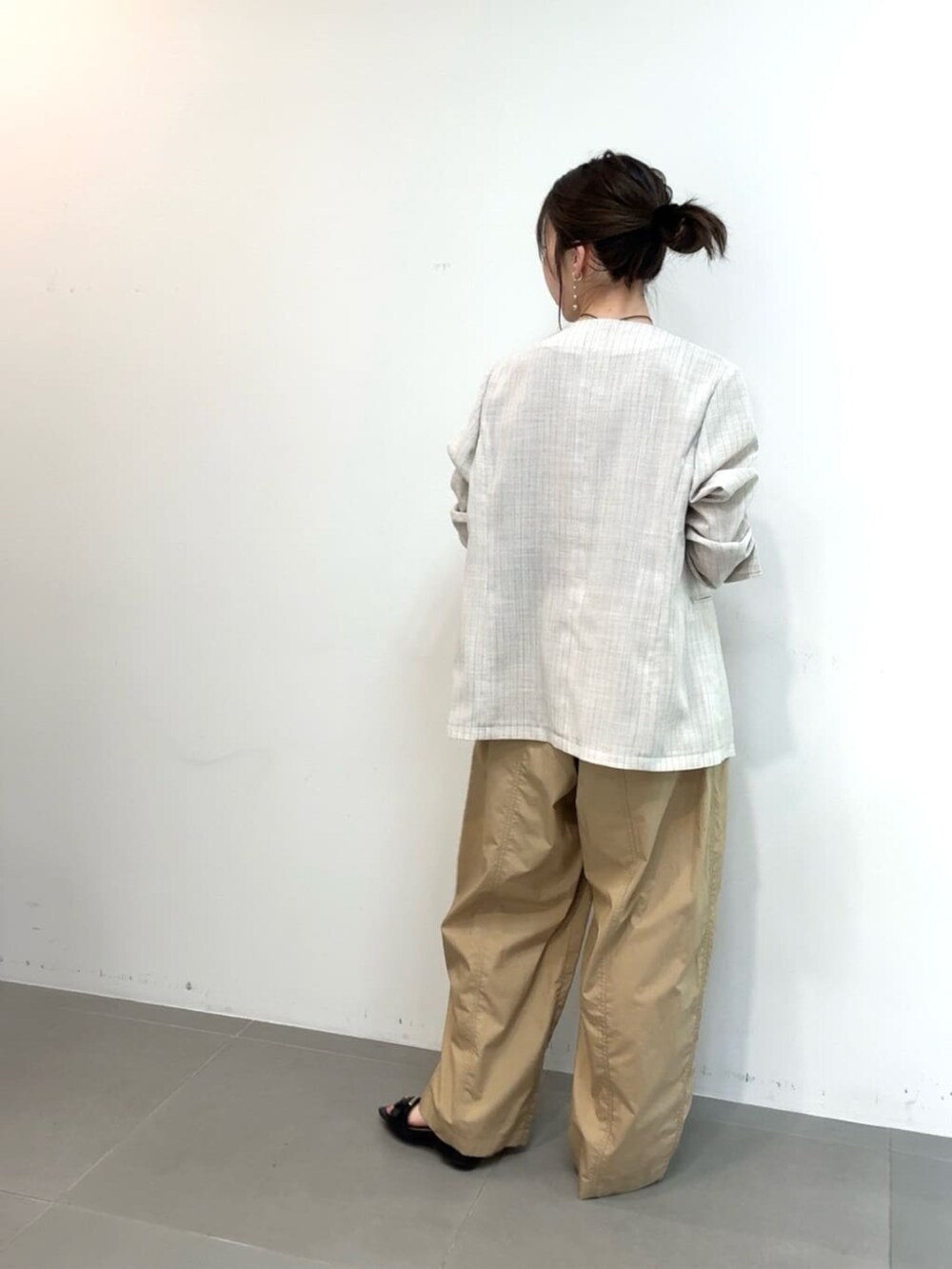 ホワイト系のノーカラージャケット、ベージュ系のその他パンツ、ブラウン系のベルトを着用したレディースの夏コーディネートの3枚目の写真