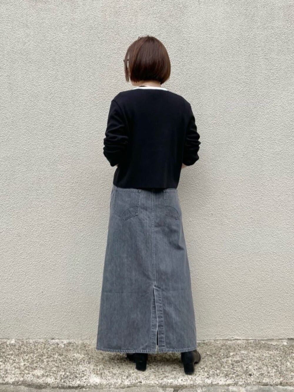 ホワイト系のニット/セーター、ブラック系のカーディガン/ボレロ、グレー系のスカートを着用したレディースの秋コーディネートの10枚目の写真