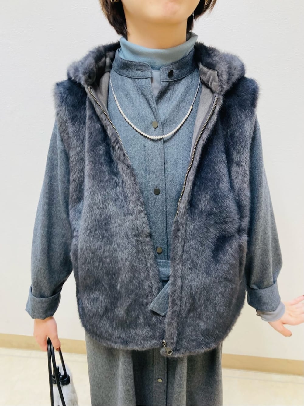 グレー系のベスト、グレー系のワンピースを着用したレディースの秋コーディネートの5枚目の写真