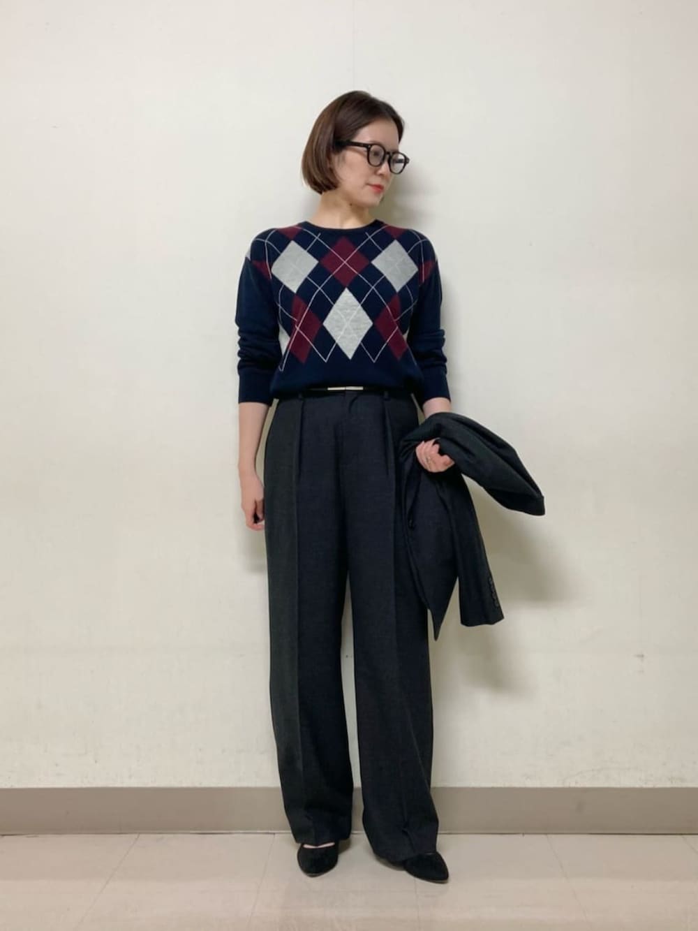 グレー系のスーツパンツ、グレー系のスーツジャケット、ブルー系のニット/セーターを着用したレディースの冬コーディネートの5枚目の写真