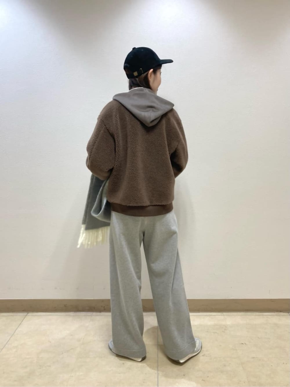 ブラウン系のブルゾン、グレー系のその他パンツ、ブラック系のキャップを着用したレディースの冬コーディネートの3枚目の写真