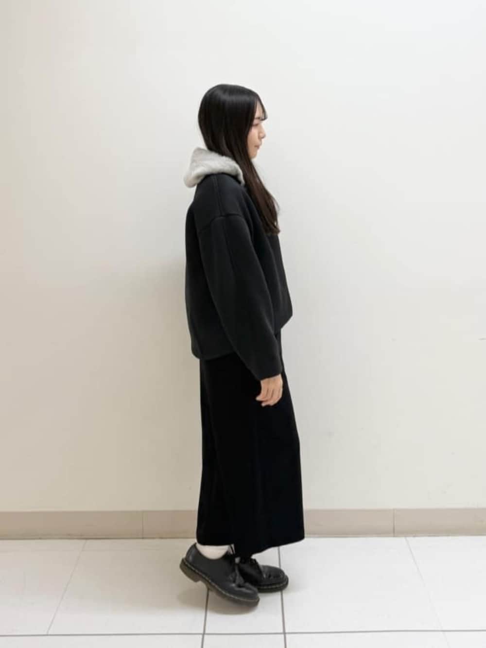 ベージュ系のパーカー、ブラック系のスカート、ブラック系のブルゾンを着用したレディースの冬コーディネートの3枚目の写真