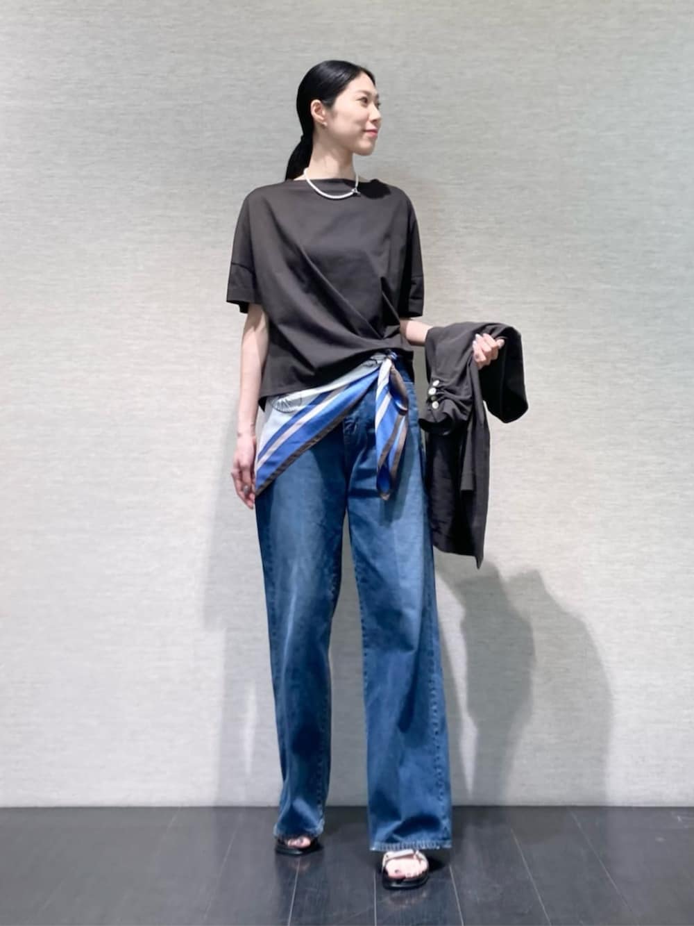ブルー系のデニムパンツ、グレー系のテーラードジャケット、グレー系のサンダルを着用したレディースの夏コーディネートの5枚目の写真