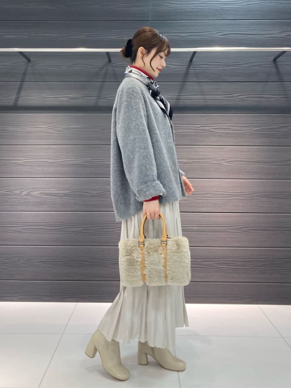ホワイト系のブーツ、ホワイト系のスカート、グレー系のその他アウターを着用したレディースの冬コーディネートの2枚目の写真