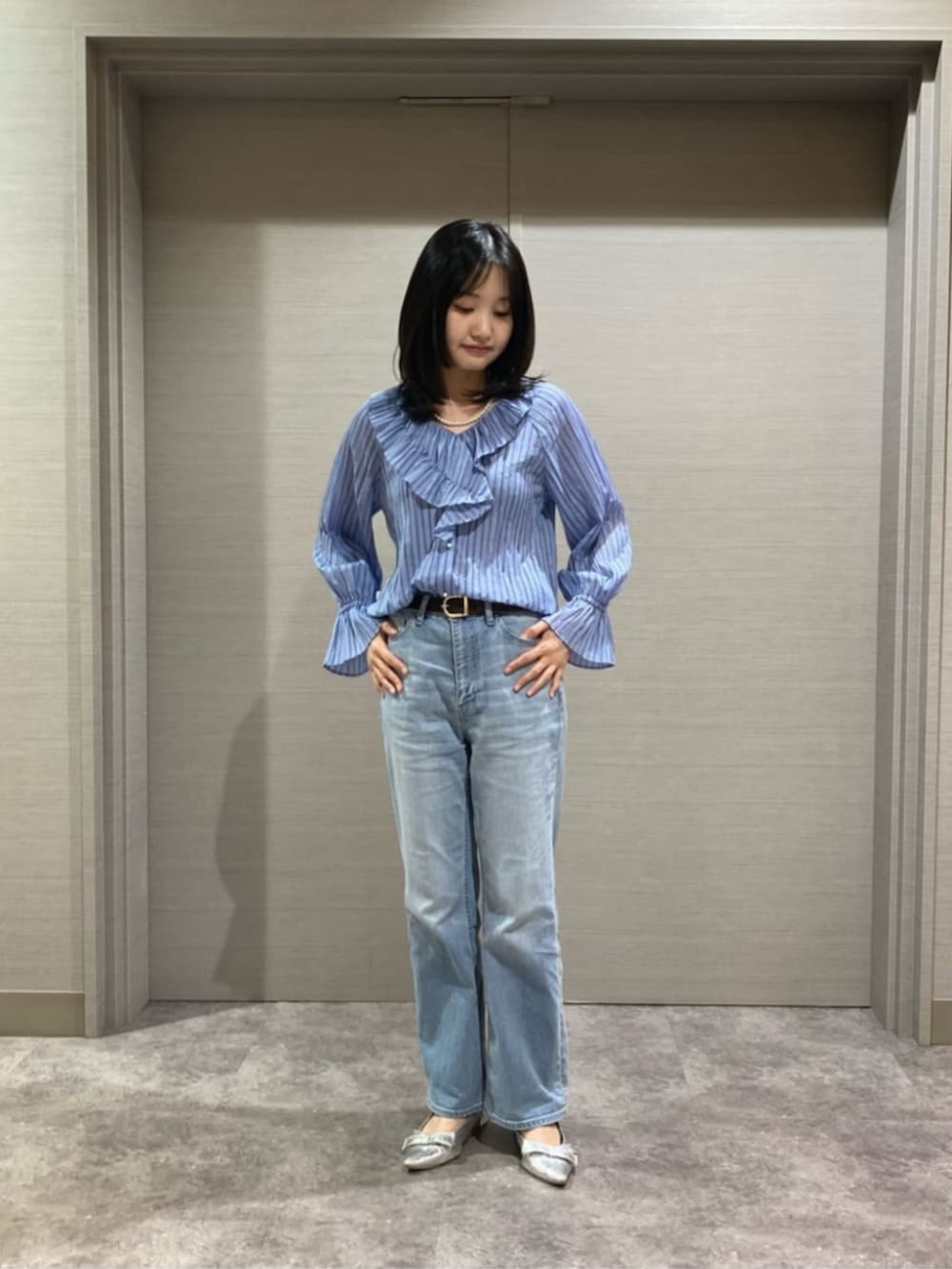 ホワイト系のショルダーバッグ、ブルー系のシャツ/ブラウス、ブラック系のベストを着用したレディースの春コーディネートの4枚目の写真