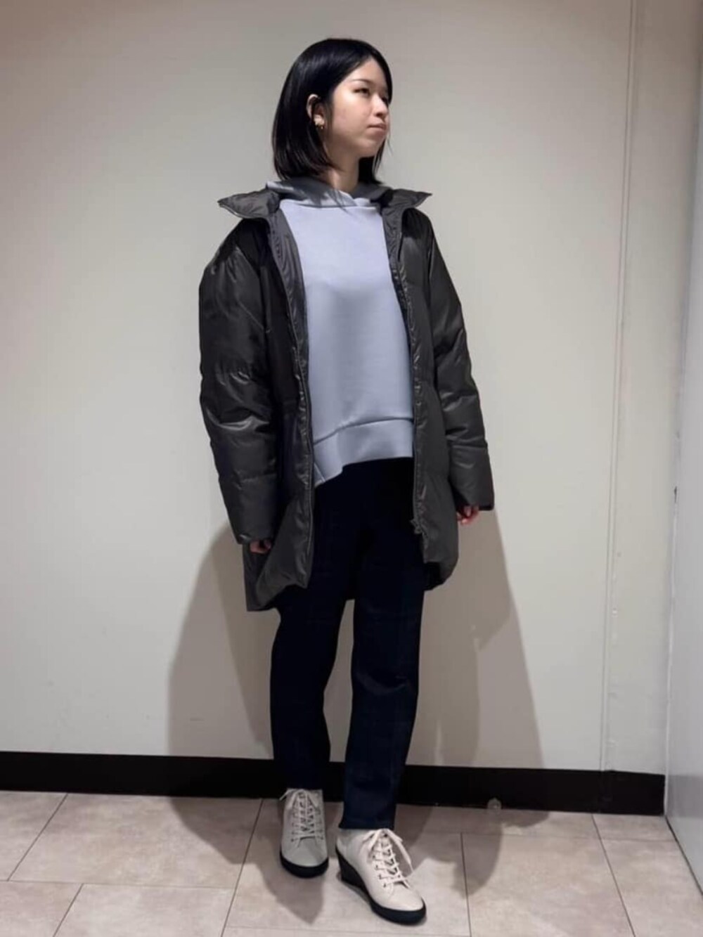 グレー系のダウンジャケット/コート、ブラウン系のその他パンツ、ブルー系のパーカーを着用したレディースの冬コーディネートの2枚目の写真