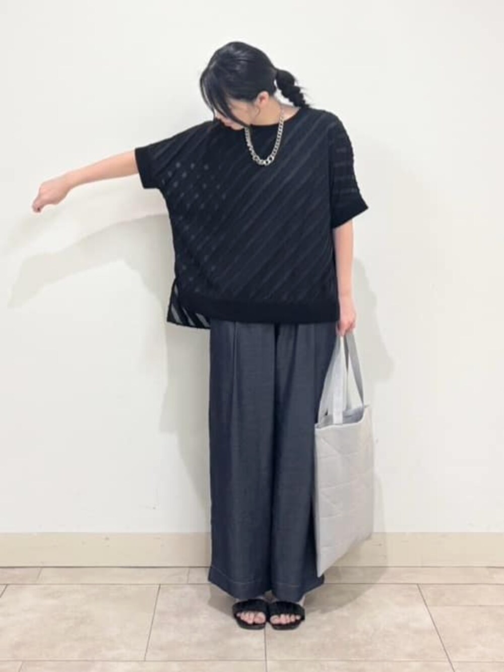 ブルー系のその他パンツ、シルバー系のトートバッグ、ブラック系のシャツ/ブラウスを着用したレディースの秋コーディネートの3枚目の写真