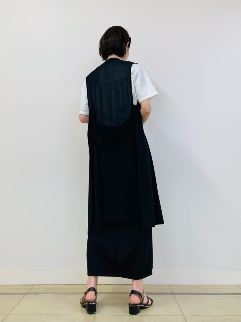 ホワイト系のTシャツ/カットソー、ブラック系のベスト、ブラック系のスカートを着用したレディースの夏コーディネートの4枚目の写真