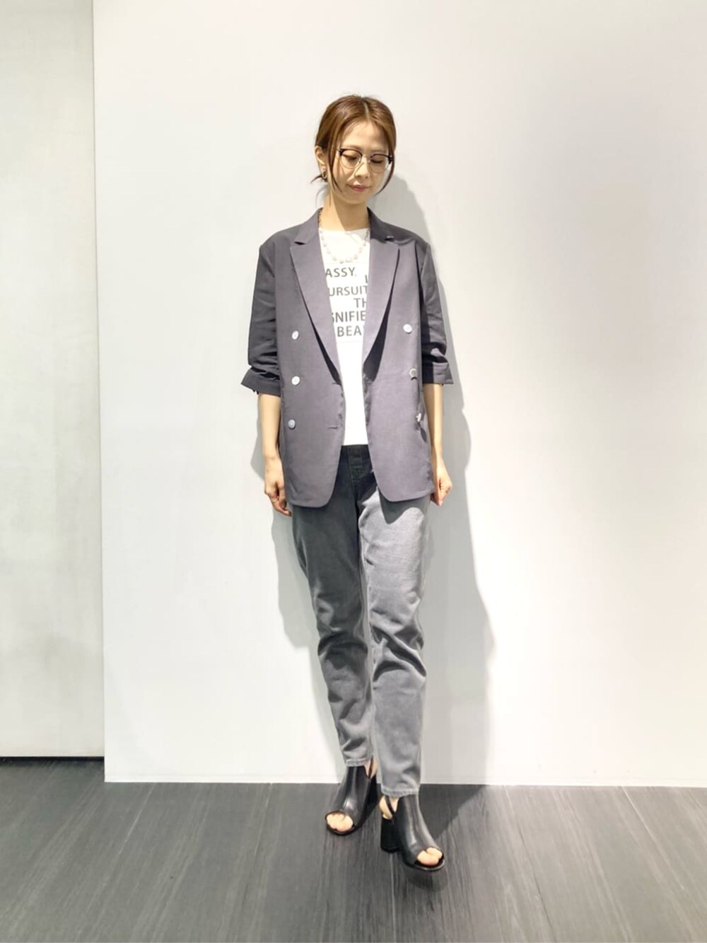 ホワイト系のTシャツ/カットソー、グレー系のテーラードジャケット、ブラック系のサンダルを着用したレディースの春コーディネートの3枚目の写真