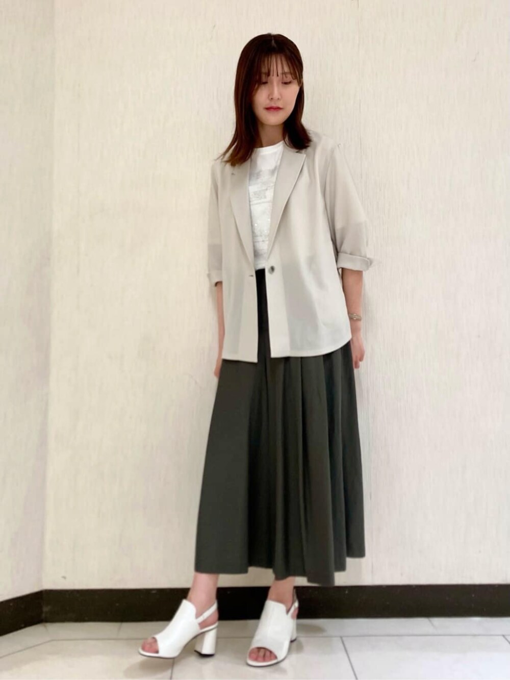 ベージュ系のテーラードジャケット、ホワイト系のTシャツ/カットソー、グリーン系のパンツを着用したレディースの夏コーディネートの4枚目の写真