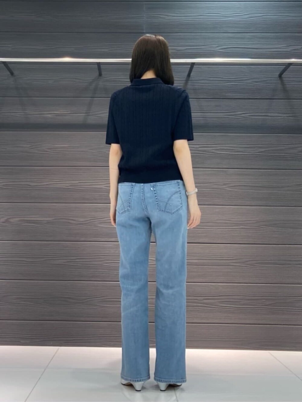 ブルー系のデニムパンツ、ブルー系のカーディガン/ボレロ、ブラウン系のボストンバッグを着用したレディースの春コーディネートの5枚目の写真