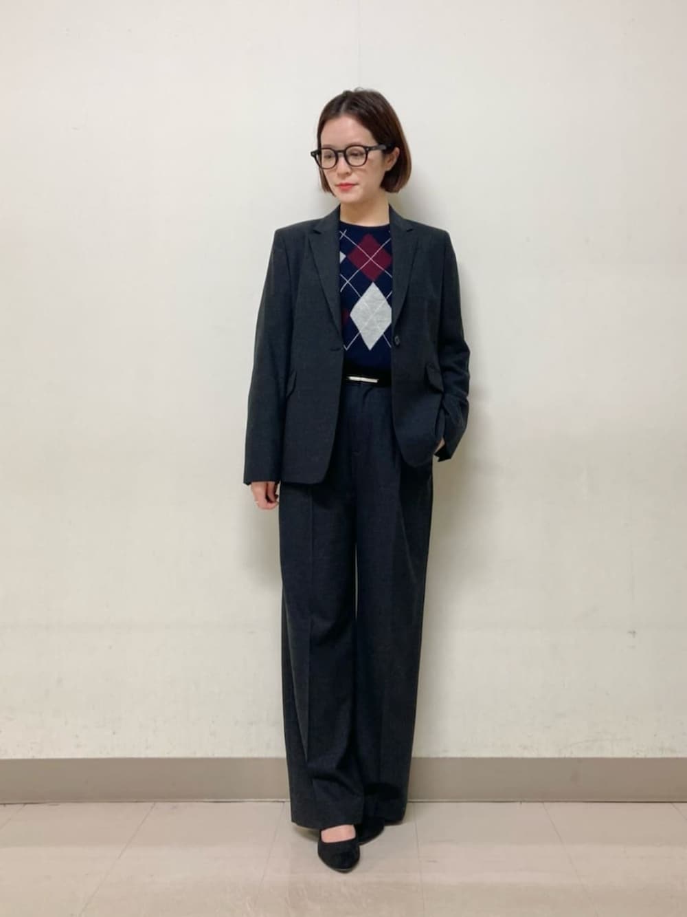 グレー系のスーツパンツ、グレー系のスーツジャケット、ブルー系のニット/セーターを着用したレディースの冬コーディネートの2枚目の写真