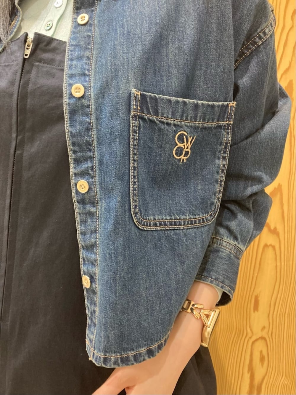 ブルー系のシャツ/ブラウス、ブルー系のジャンパースカート、イエロー系のキャップを着用したレディースの秋コーディネートの4枚目の写真