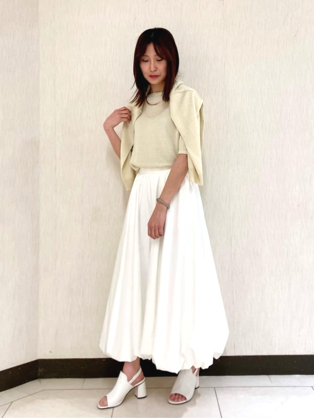 ホワイト系のスカート、イエロー系のカーディガン/ボレロ、イエロー系のニット/セーターを着用したレディースの春コーディネートの3枚目の写真