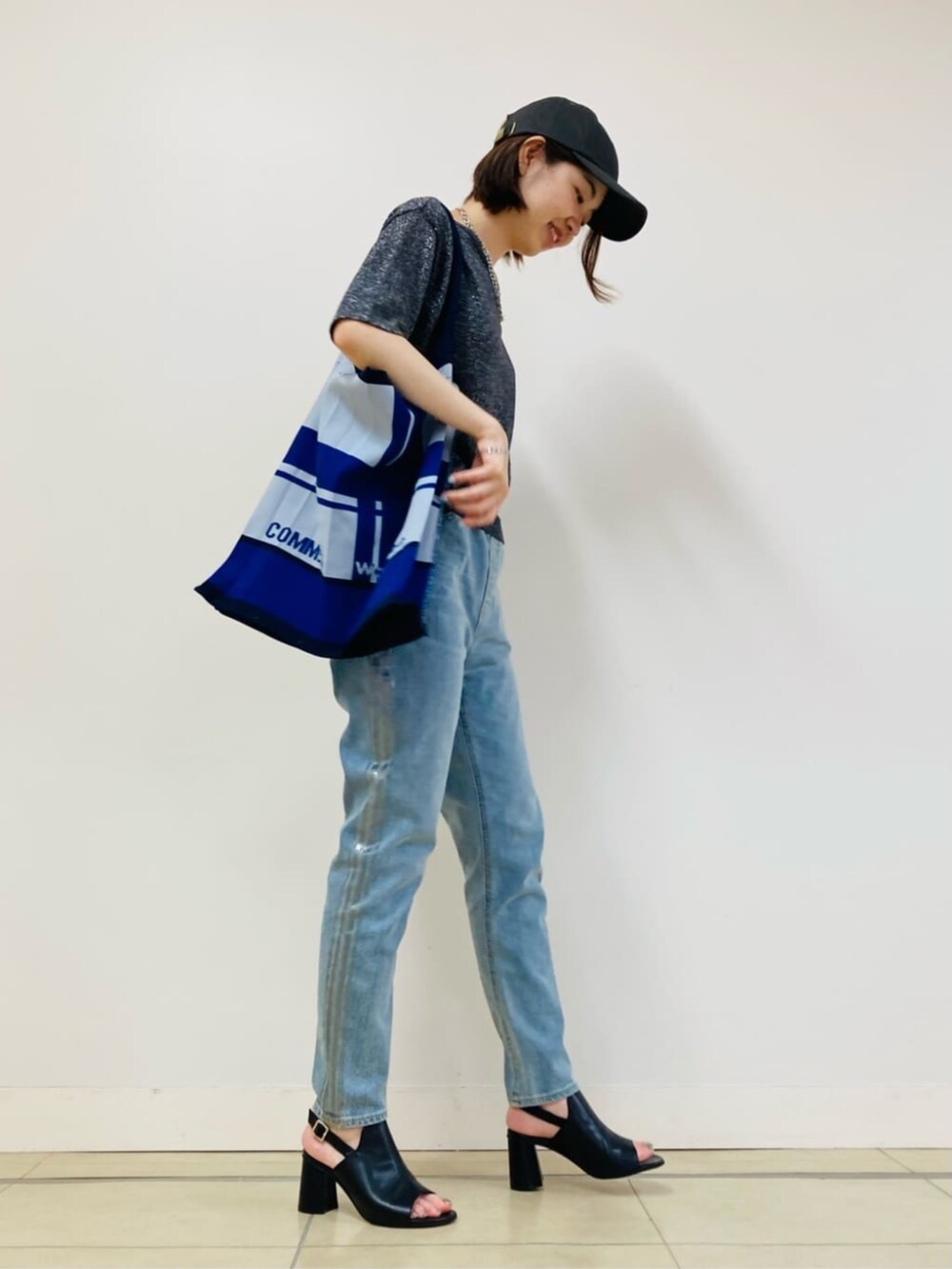 ブラック系のサンダル、ブルー系のデニムパンツ、グレー系のニット/セーターを着用したレディースの夏コーディネートの3枚目の写真