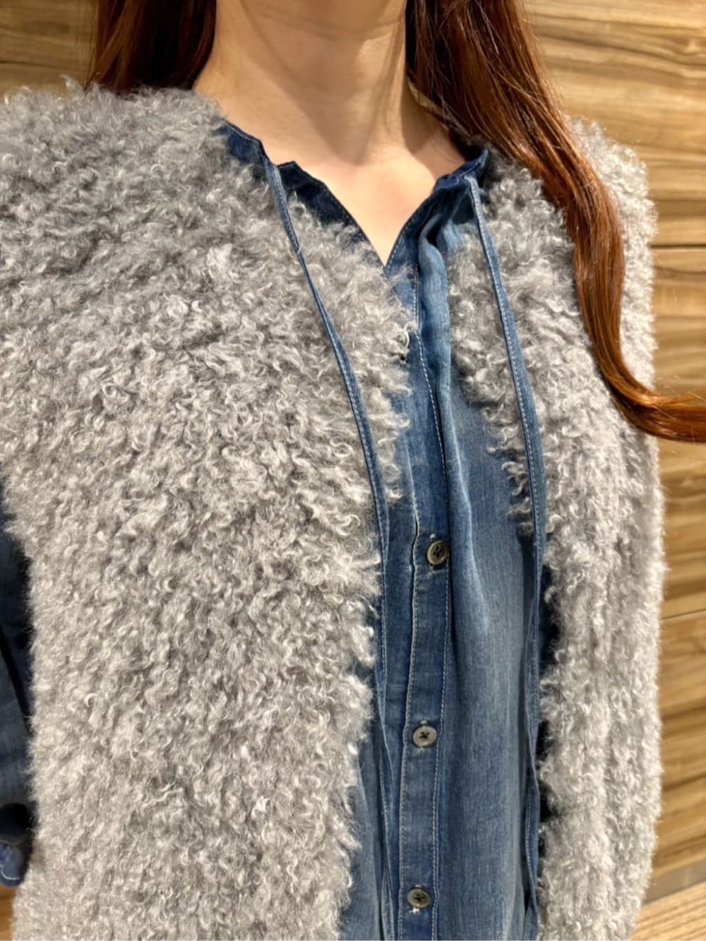 ブラック系のその他シューズ、グレー系のベスト、ブルー系のデニムパンツを着用したレディースの秋コーディネートの3枚目の写真