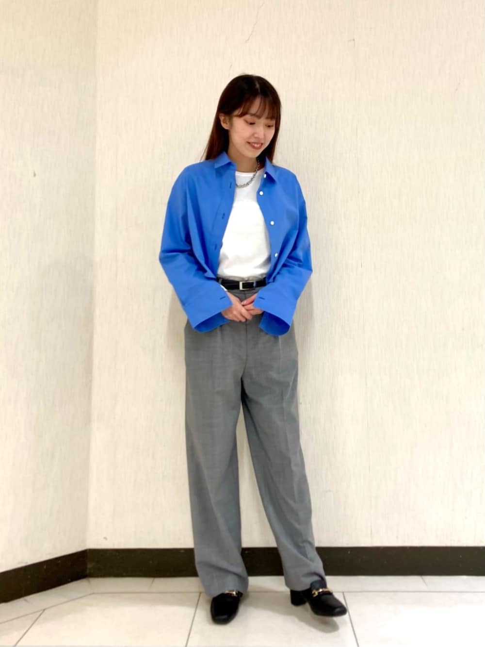 ブルー系のシャツ/ブラウス、ホワイト系のTシャツ/カットソー、グレー系のスーツパンツを着用したレディースの春コーディネートの2枚目の写真