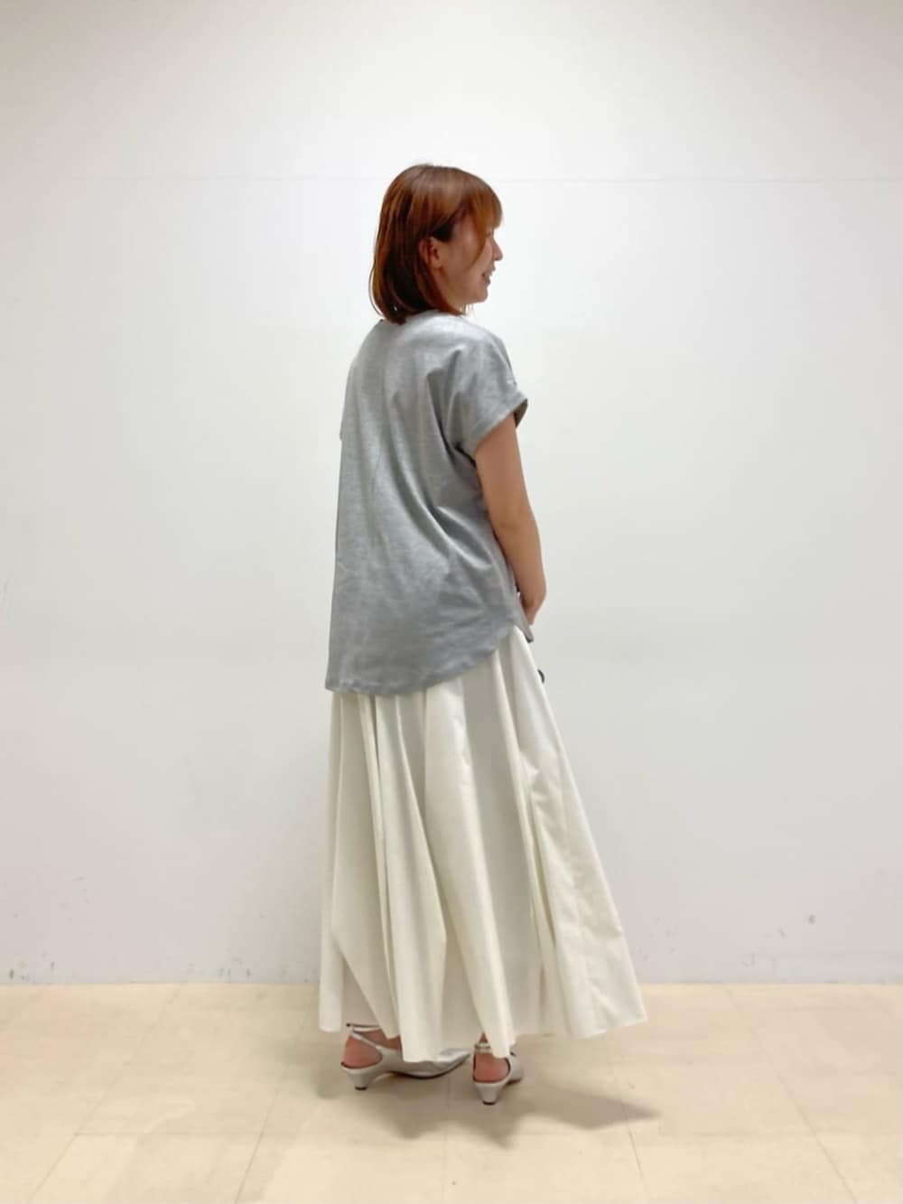 シルバー系のパンプス、グレー系のTシャツ/カットソーを着用したレディースの春コーディネートの3枚目の写真