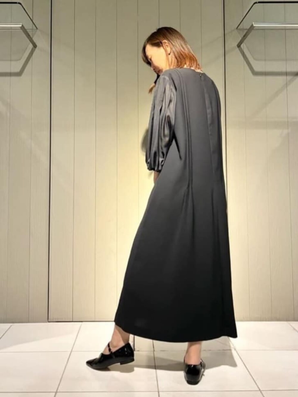 ベージュ系のノーカラージャケット、ブラック系のワンピース、ブラック系のパンプスを着用したレディースの冬コーディネートの6枚目の写真