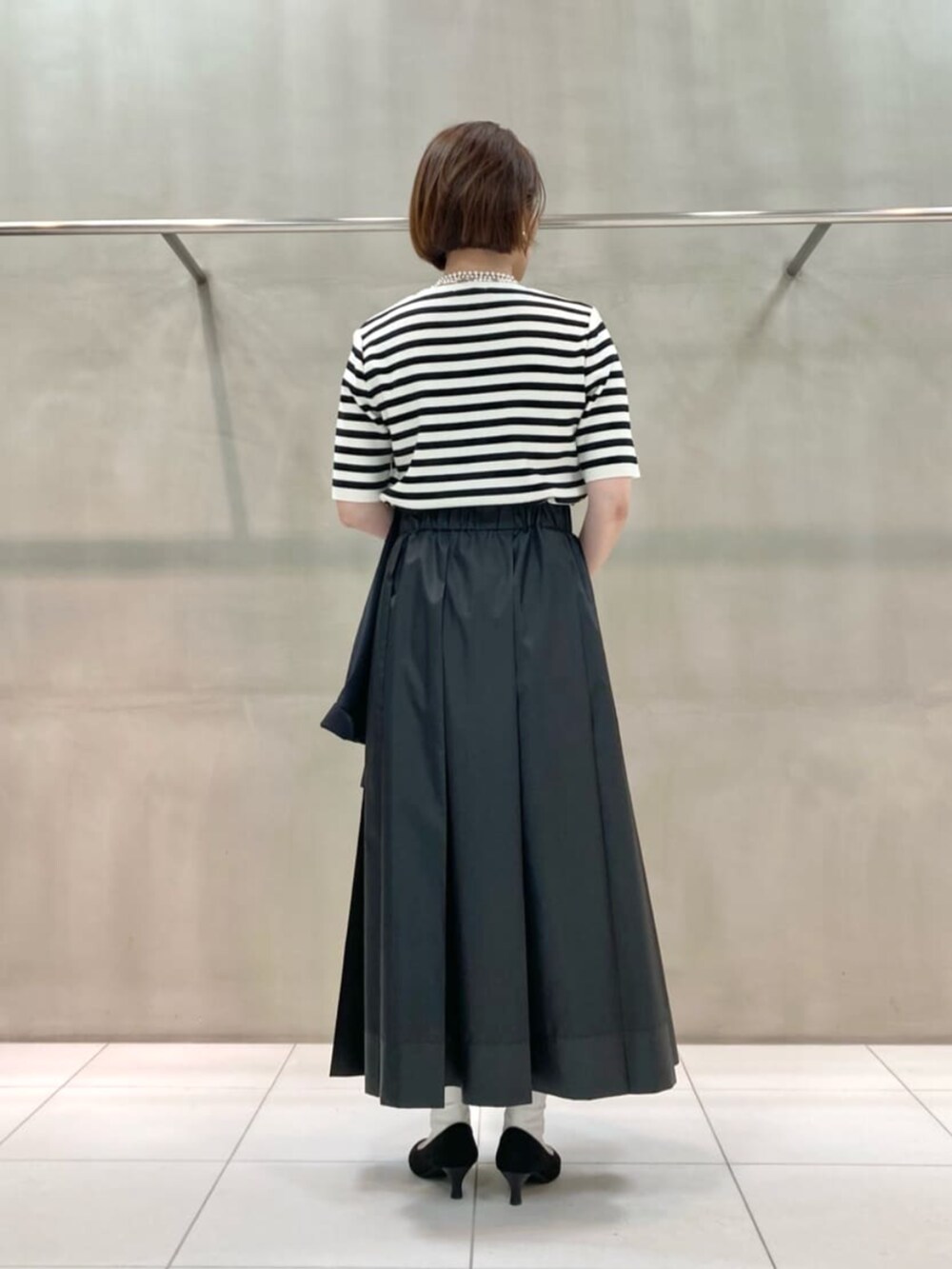 ブルー系のセットアップ、ホワイト系のニット/セーター、ブラック系のスカートを着用したレディースの春コーディネートの4枚目の写真